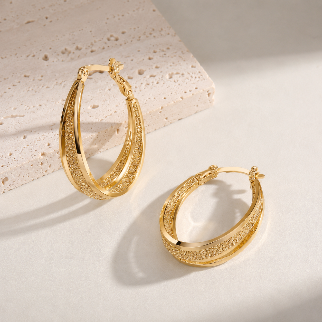 Women's textured hoop earrings with hinge clasp closure and engraved detailing