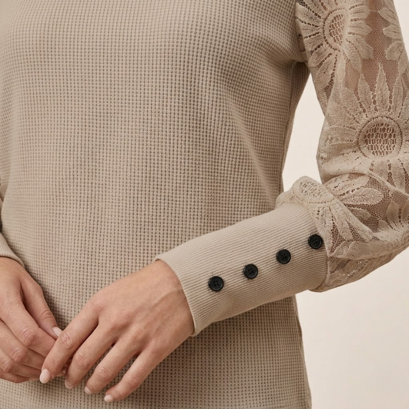 Women's long-sleeve blouse combining textured knit body with delicate lace sleeve detail