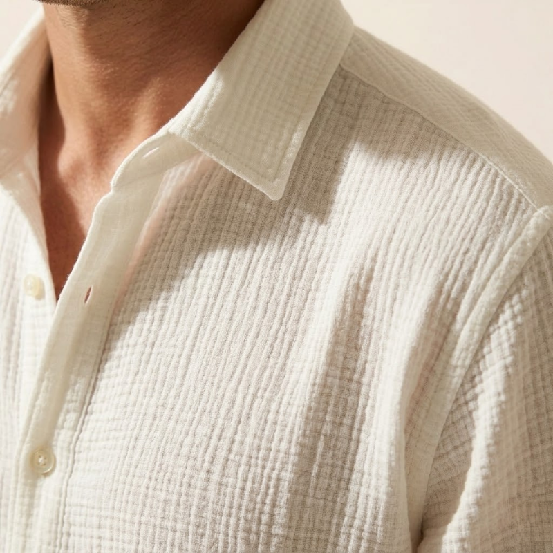 Men's long-sleeved woven shirt with clean seams, open collar, and standard length