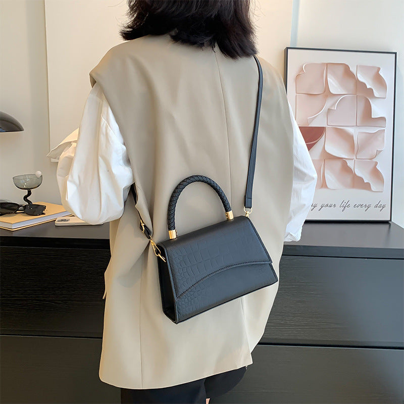 Väska i konstläder med texturerat mönster från sidan