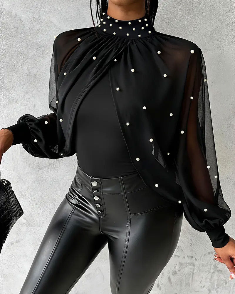 Långärmad blus med genomskinligt tyg och volangdetaljer vid ärm