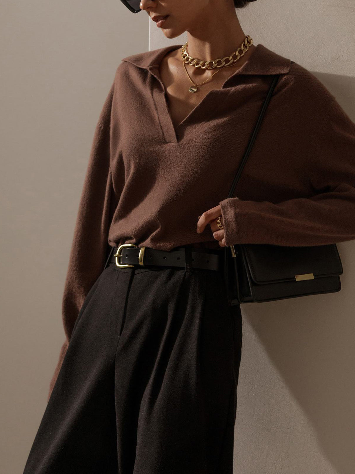 Relaxed women's knit top with soft collar, V-neck, and hip-length cut
