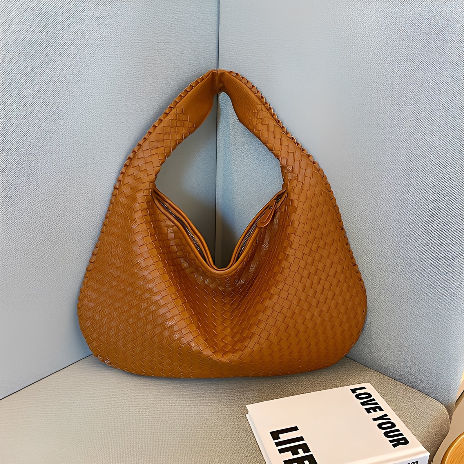 Side profile of women's woven faux leather shoulder bag with shoulder strap detail