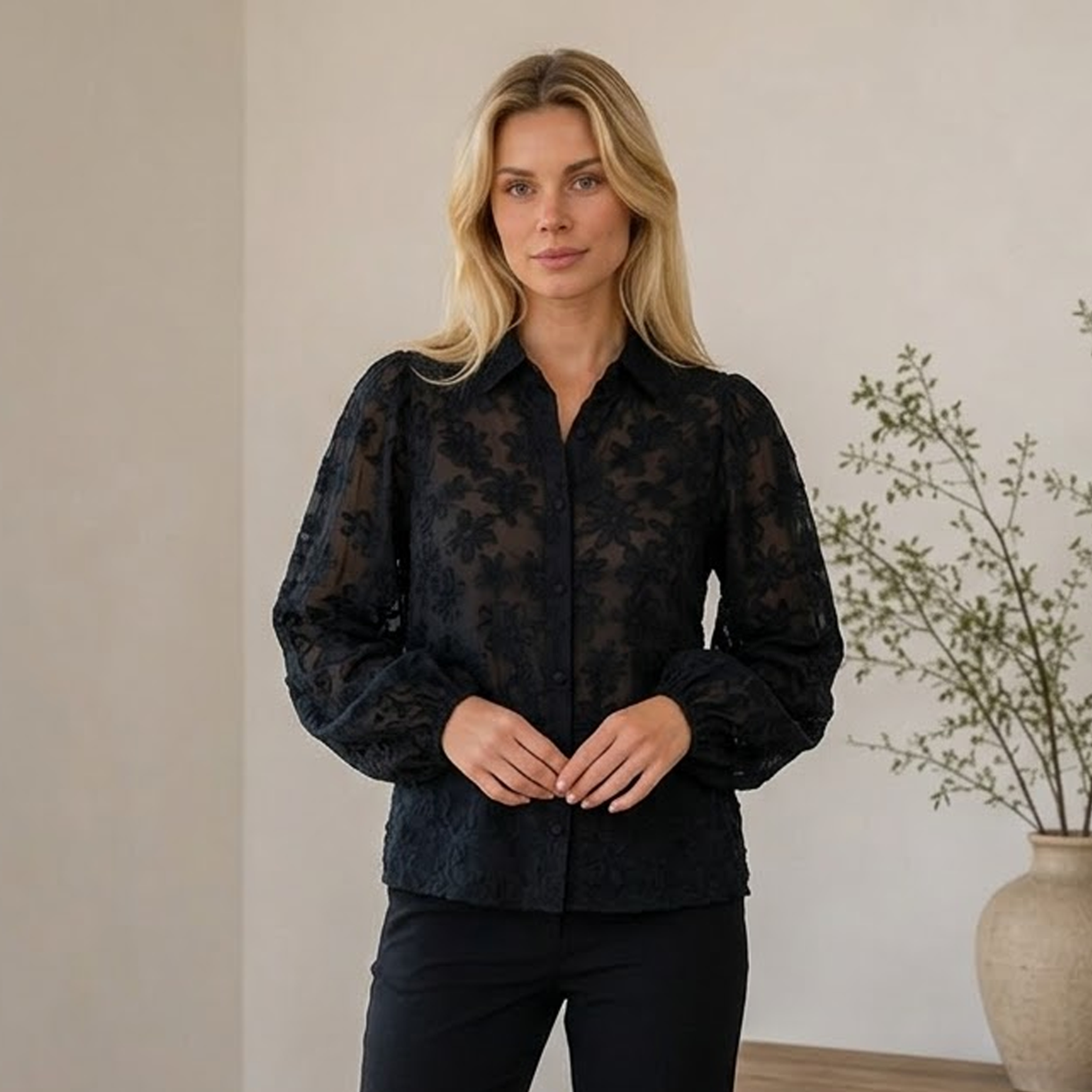 Transparent lace blouse with floral texture, front button closure, classic collar, and long sleeves with ruffled cuffs