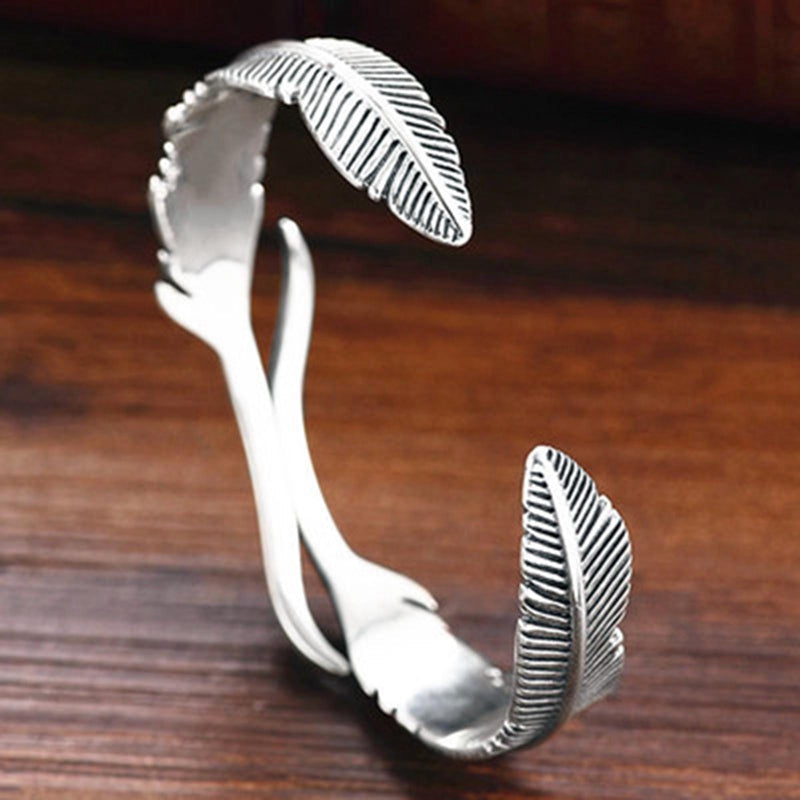 Feather bracelet flat lay, showing full cuff shape and feather design