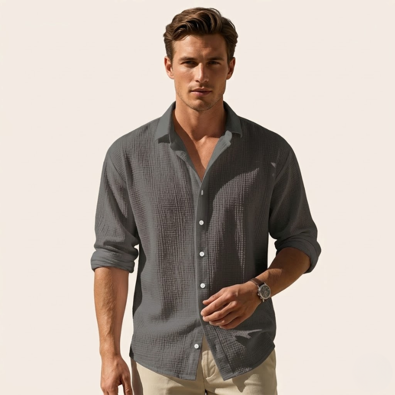 Men's long-sleeved woven shirt with a relaxed silhouette, clean seams, and rounded hem