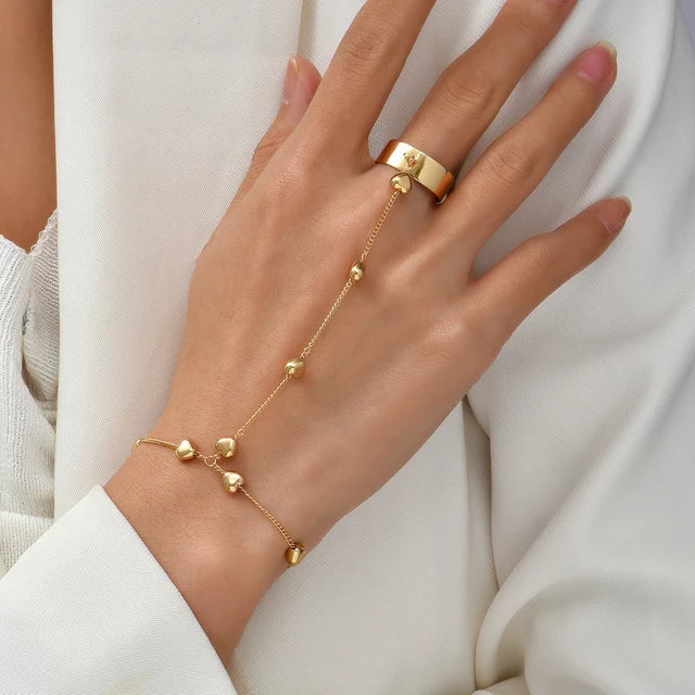 Women's adjustable hand chain with ring detail, thin metal links and smooth clasp at the wrist