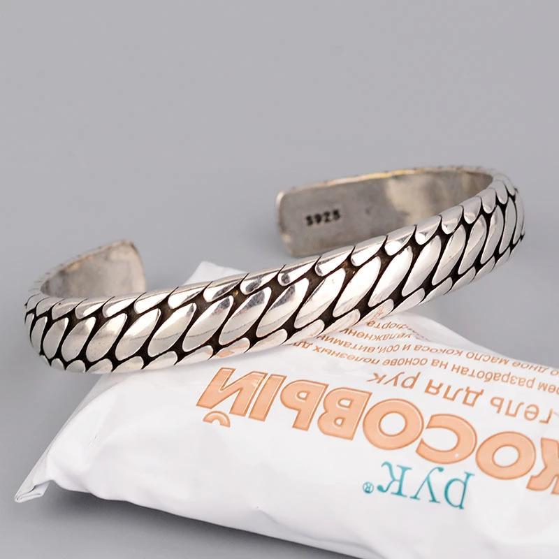Close-up of textured metal alloy cuff bracelet with polished finish detail