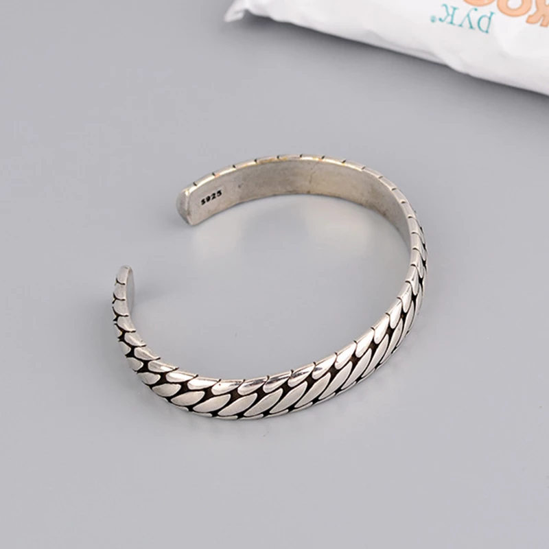 Unisex cuff bracelet with open design shown from a side angle