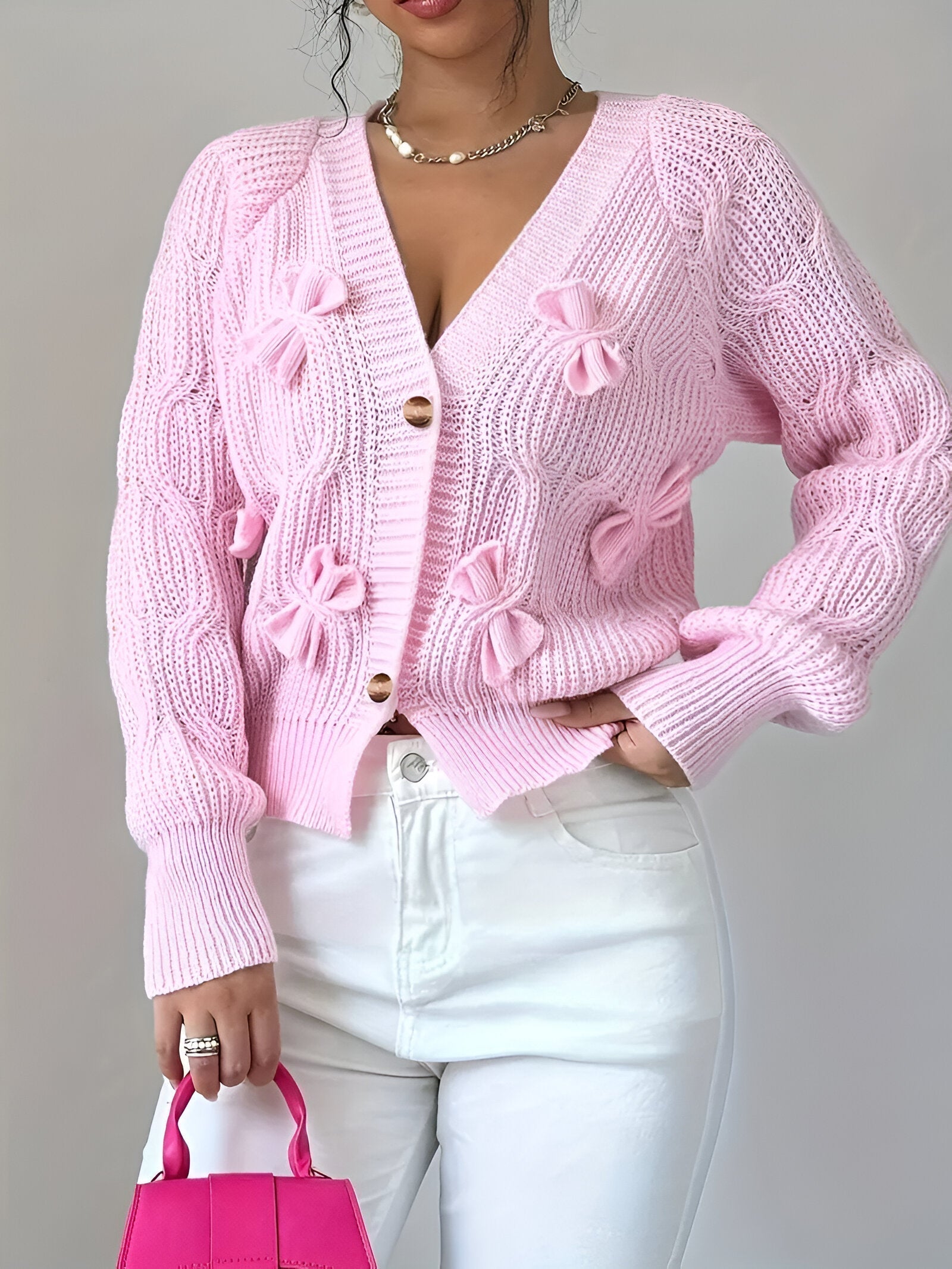 Close-up of decorative bow detail on women's knitted cardigan