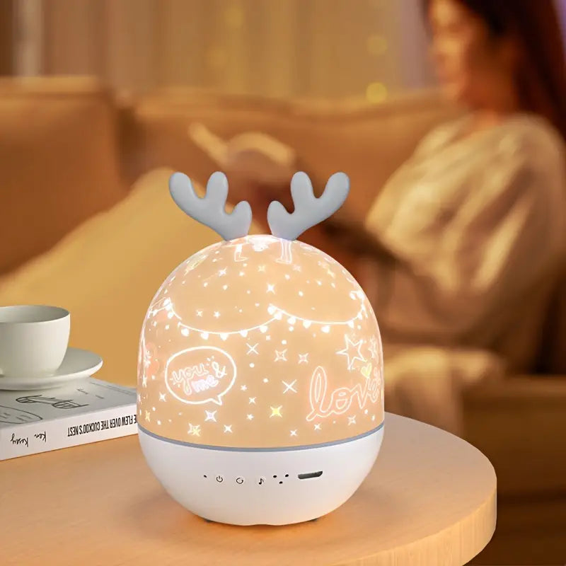 Kids' rechargeable starry sky projector with deer ear dome illuminated in a dark room