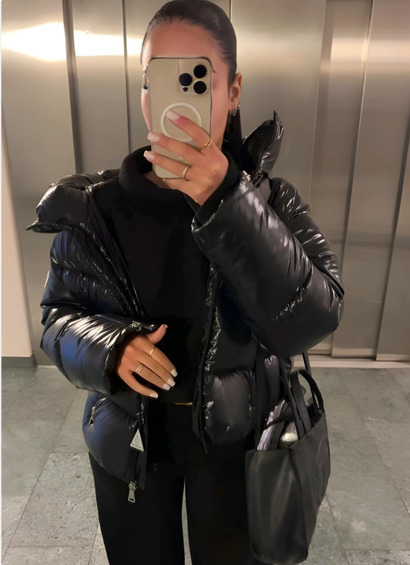Women's hooded puffer jacket with padded quilted construction, close-up detail view