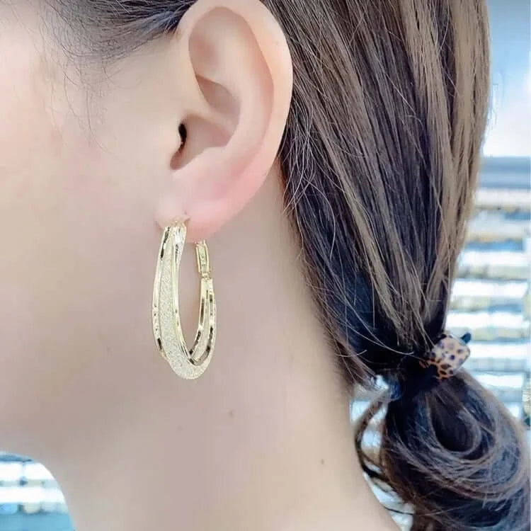 Women's textured hoop earrings with hinge clasp closure and engraved detailing