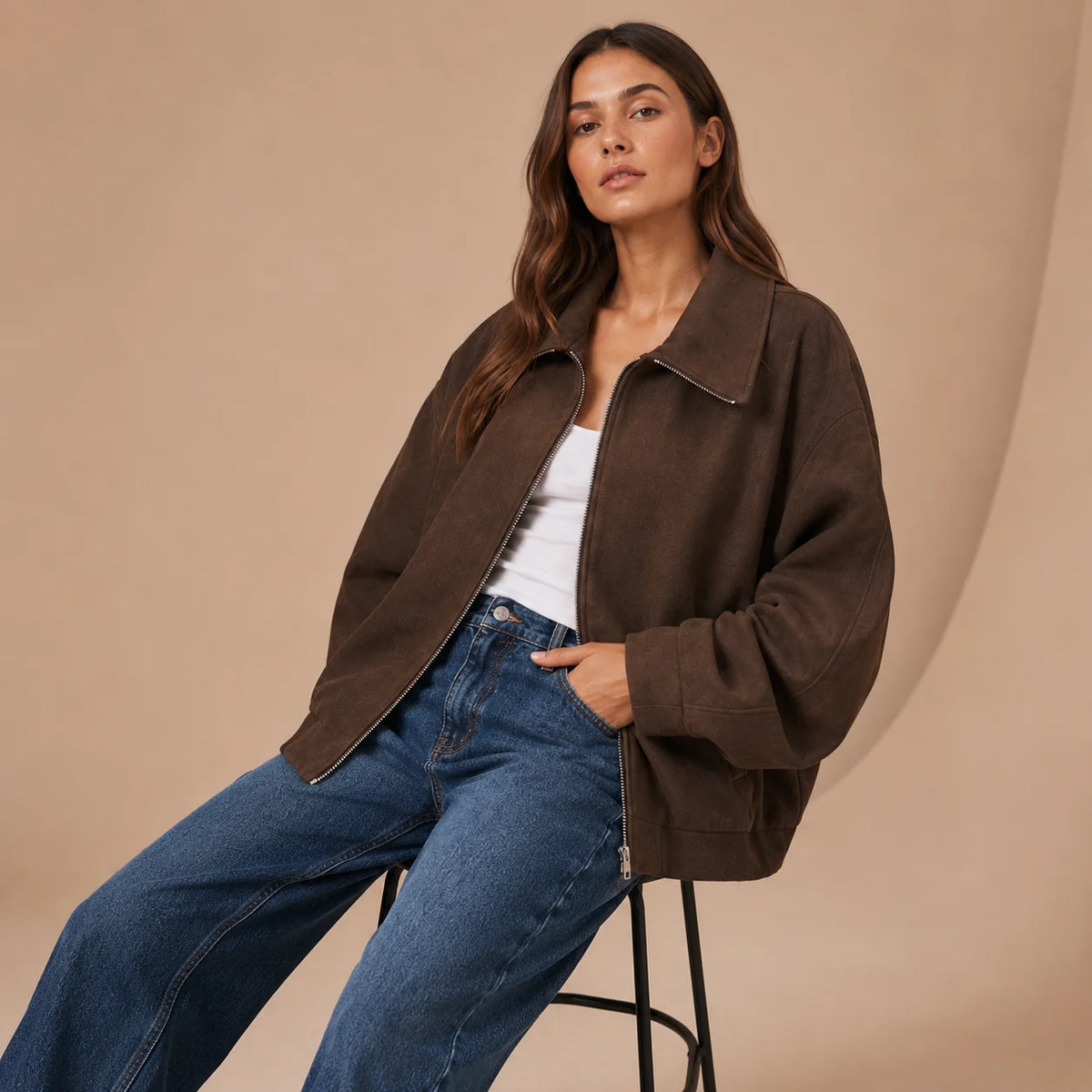 Woman wearing brown loose fit zip jacket seated front view